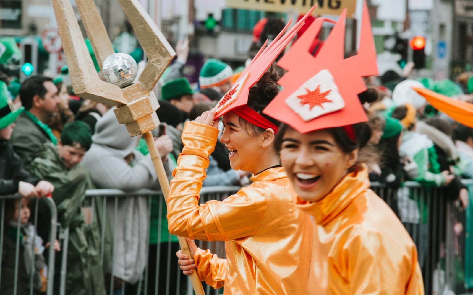 Close up laughing performer girls in orange at parade